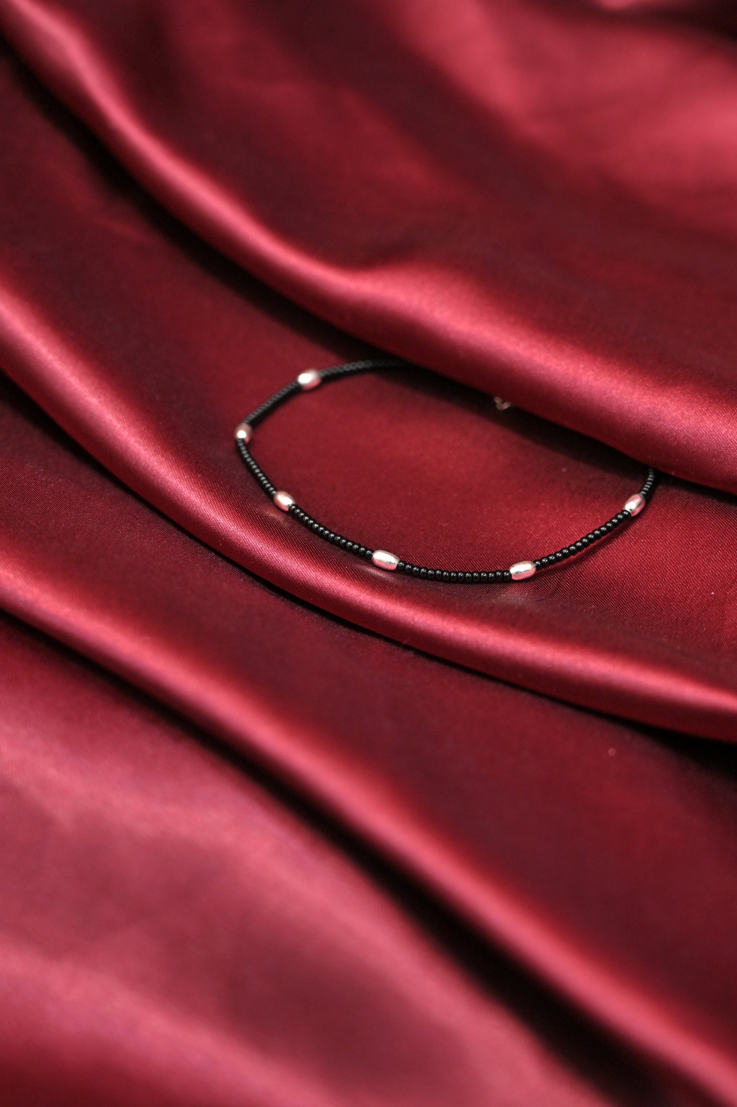 minimal black beaded anklet with silver accents